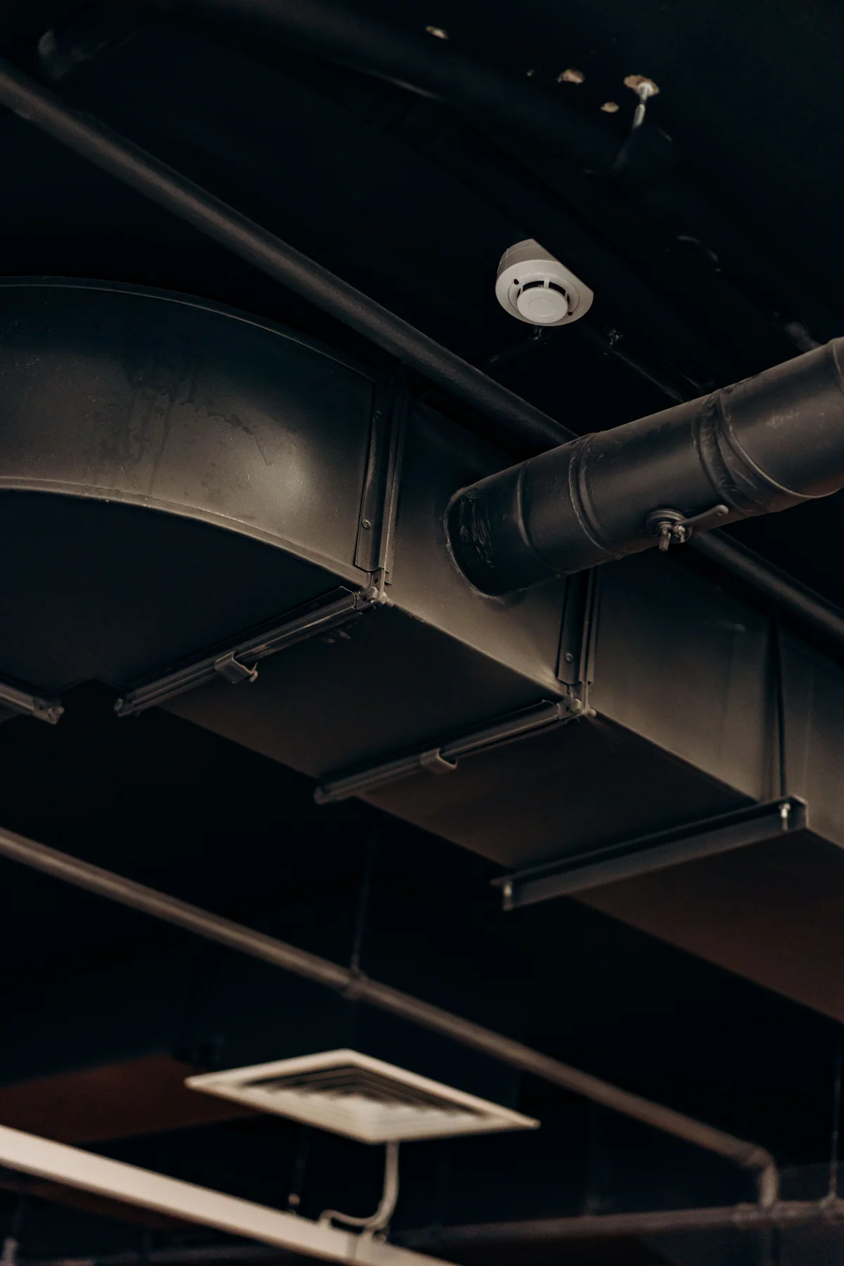 Metal ventilation ducts and a ceiling air vent.